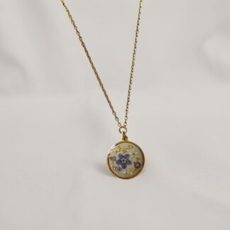 Collier médaillon rond fleur de myosotis