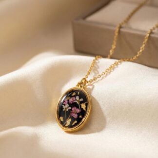 Collier médaillon ovale noir fleurs roses et blanches