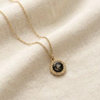 Médaillon rond noir fleurs blanches et feuilles d’or