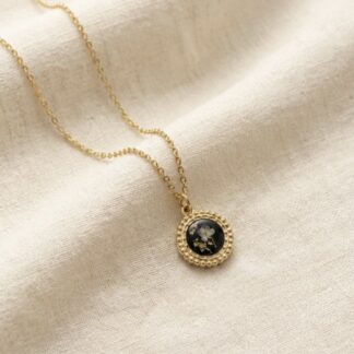 Médaillon rond noir fleurs blanches et feuilles d’or