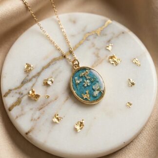 Collier médaillon bleu fleurs blanches et feuilles d'or