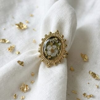 Bague verte et fleur séchée blanche